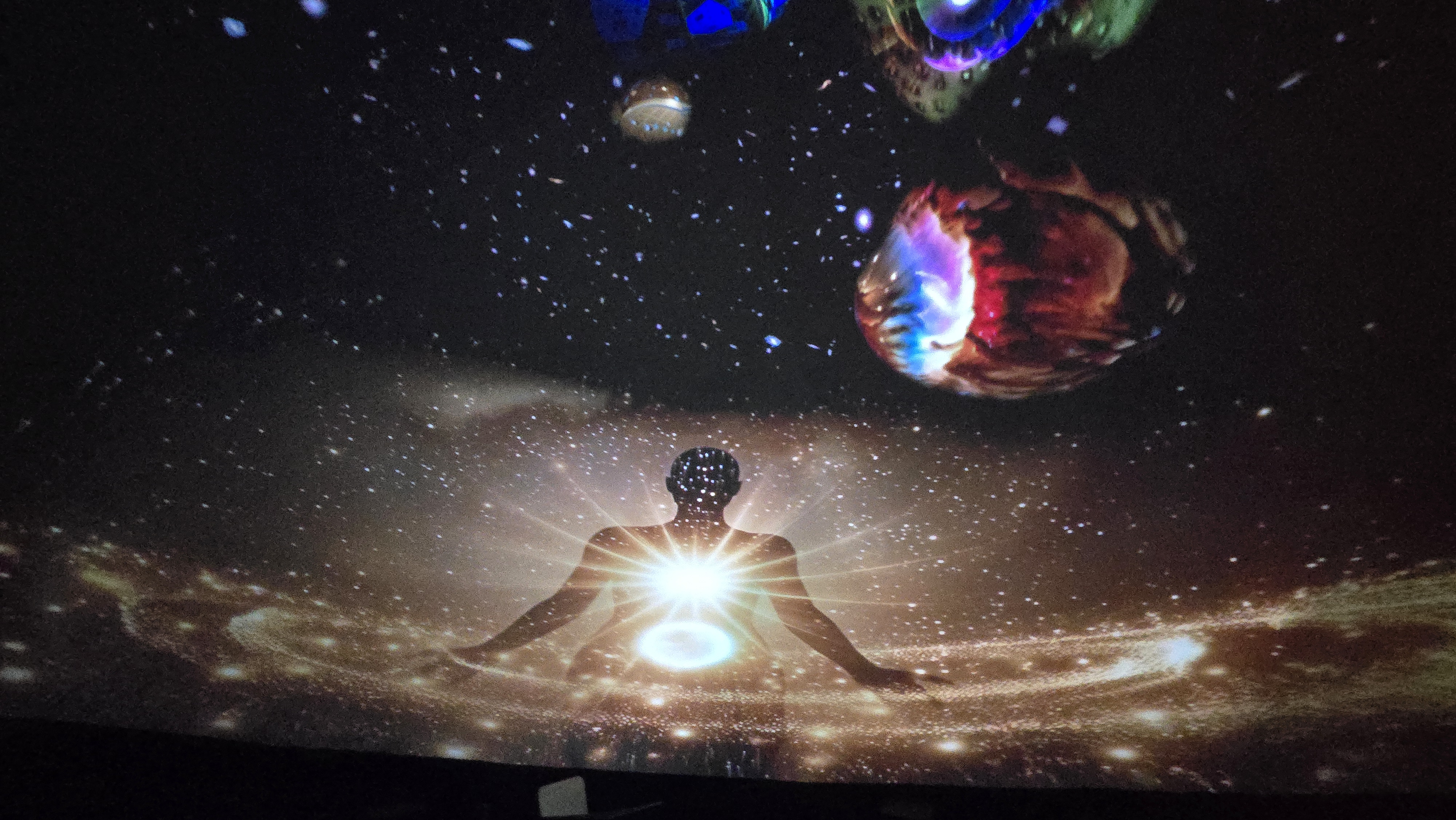 Meditating figure radiating light beneath cosmic dome